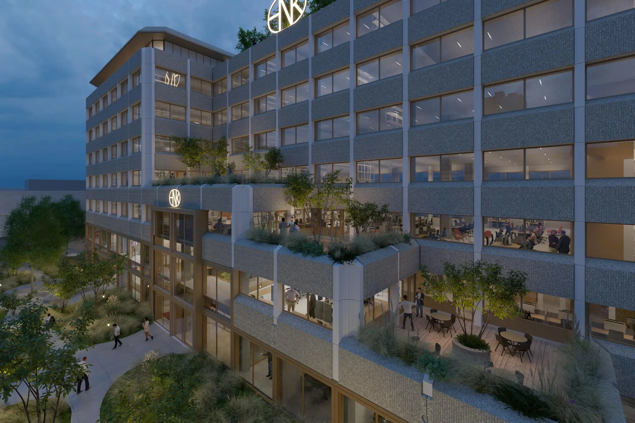 Avondbeeld van een modern kantoorgebouw aan de Marten Meesweg met verlichte kantoren, dakterrassen en groenvoorziening.